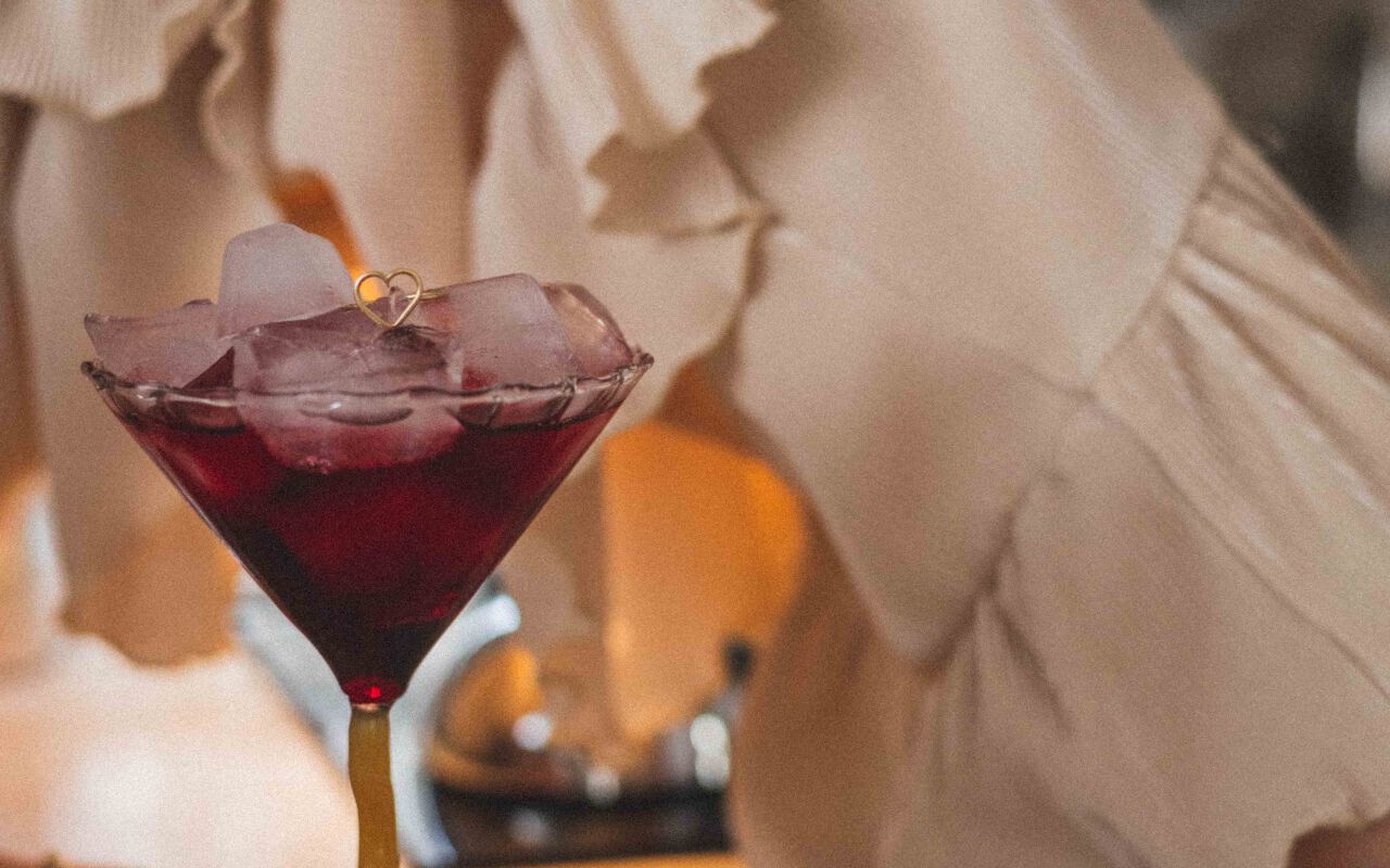 Delikatny pierścionek z sercem ułożony na kieliszku, wykonany ze srebra próby 925 i pokryty złotem